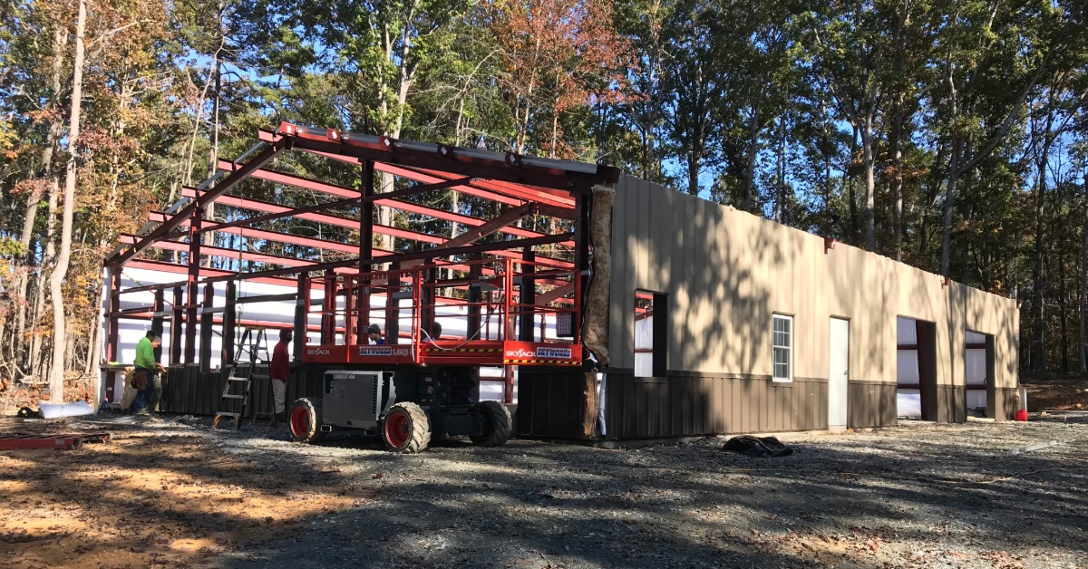 A large, 2-story metal building with a small crane parked out front. Text on the building reads "BLDG 3."